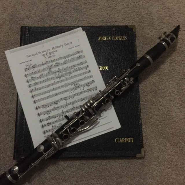 My clarinet, in front of a piece of sheet music and my music binder
